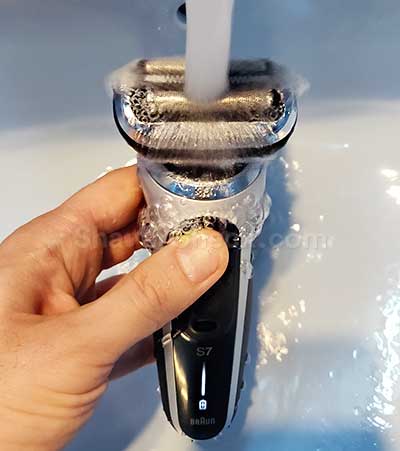 Rinsing the shaver with warm tap water.
