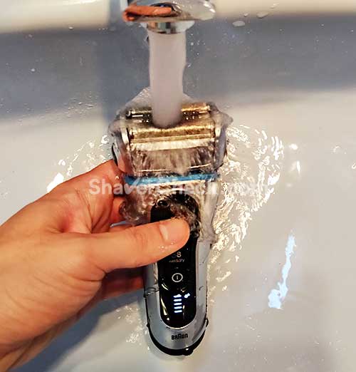 Cleaning the shaver with water.