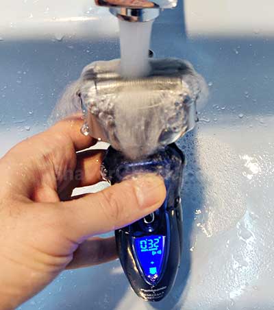 Rinsing the shaver with tap water.