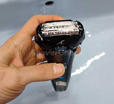 Cleaning the razor with water and soap.