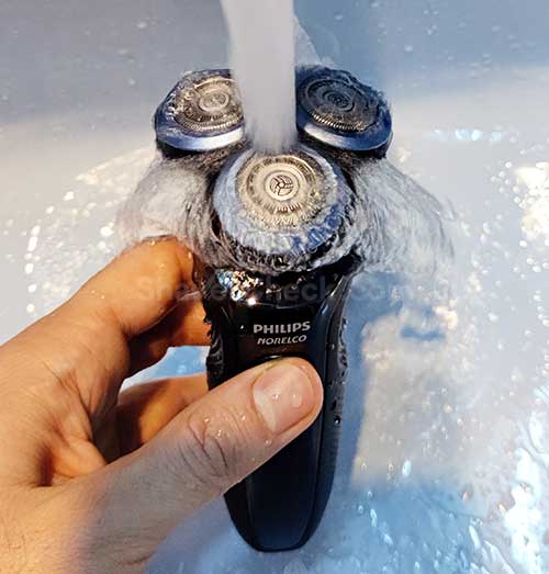 Rinsing the shaver with water.