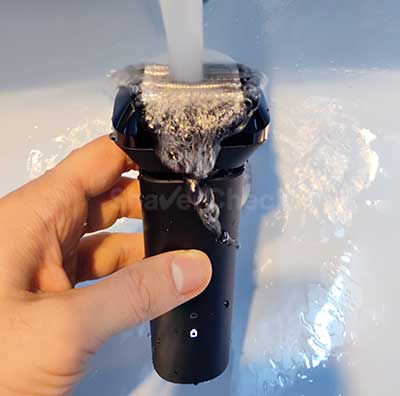 Cleaning the Xiaomi shaver with water.